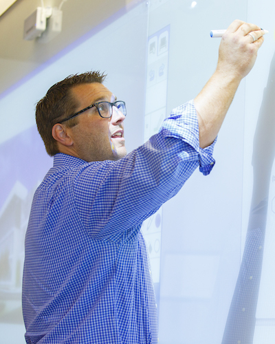 Faculty member writing on board.